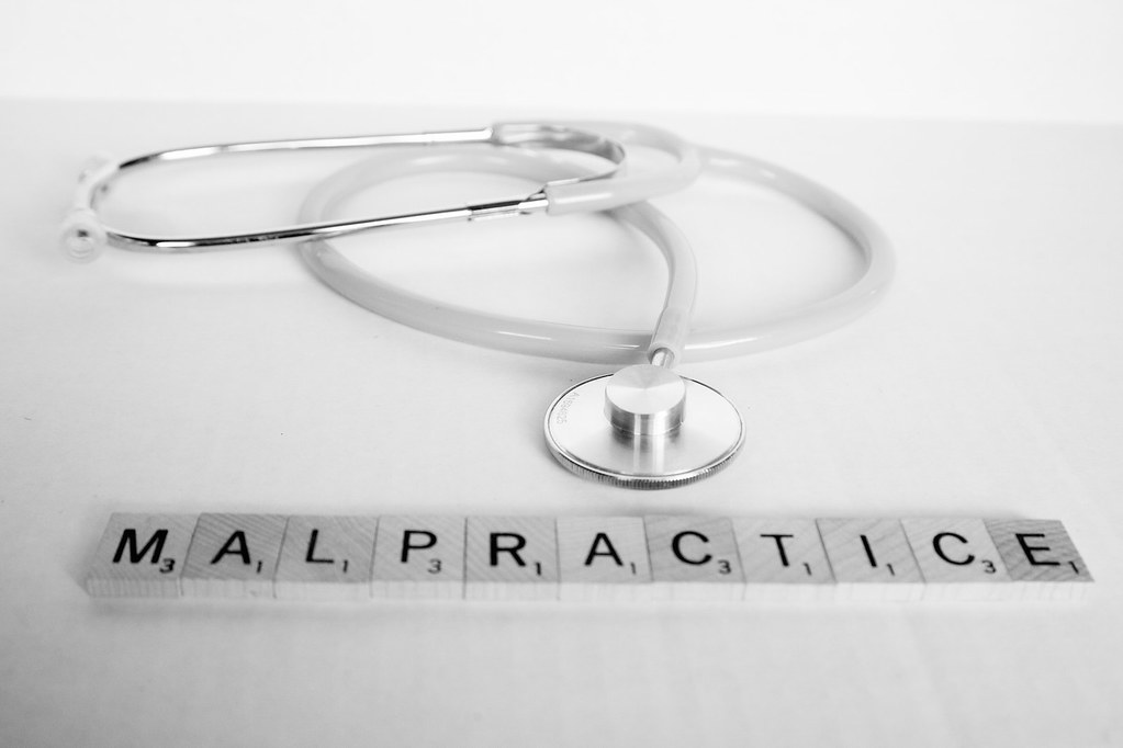 stethoscope with malpractice in scrabble letters